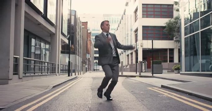 Contemporary funky caucasian businessman street dancer dancing freestyle in the city