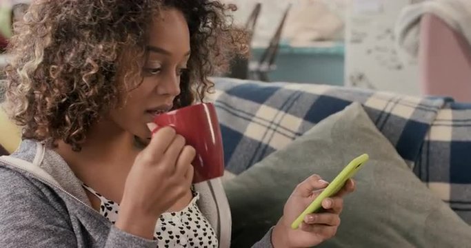 Young student using smart phone at home in  morning drinking coffee