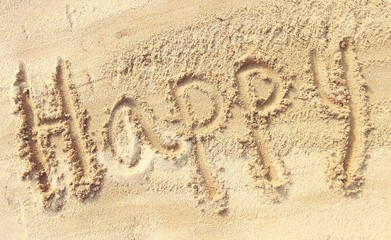 Happy - sand writing on the beach