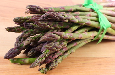 Green asparagus on wooden surface, healthy eating