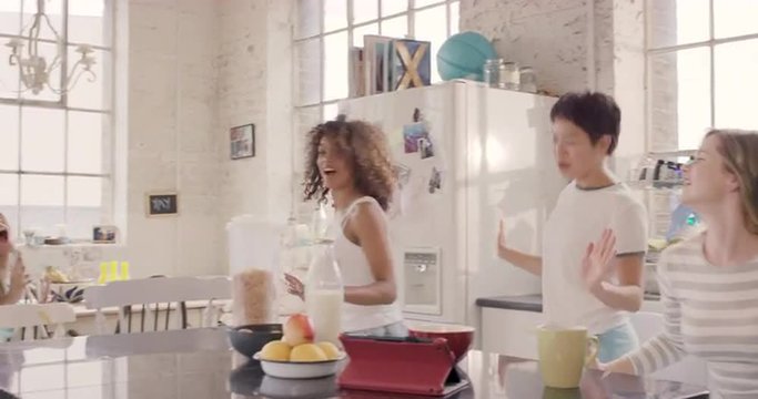 Young group of girl friends  dancing in kitchen wearing pyjamas