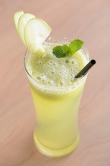 Green apple smoothie with mint on a wooden table