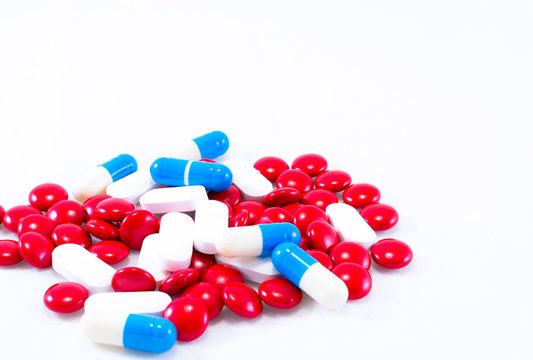 Red, blue and white pills on a white background