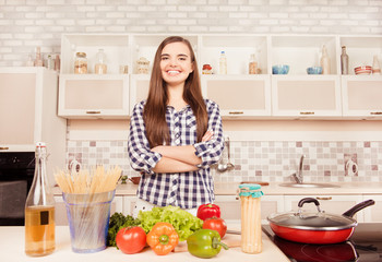 Attractive housewife posing with crossed hands in the kitchen