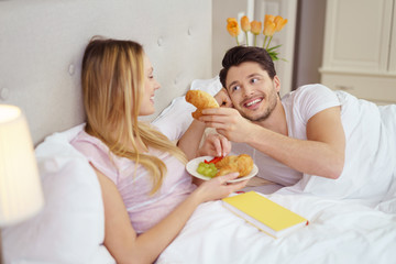 glückliches paar frühstückt im bett