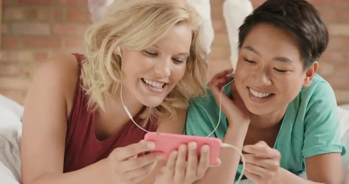 Girl friends listening to music sharing smart phone