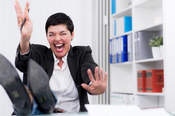 frau am schreibtisch jubelt vor freude