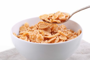 corn and rice flakes in a white bowl and spoon