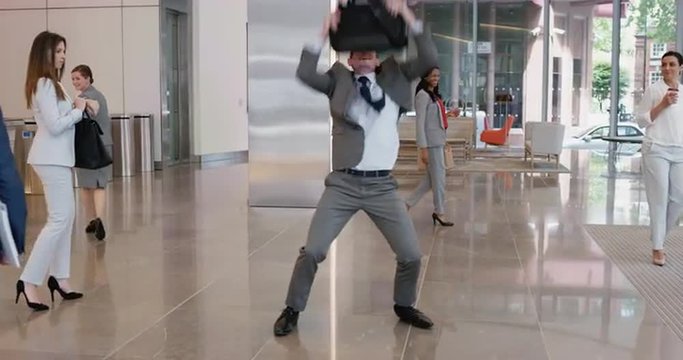 Crazy happy businessman dancing in corporate lobby