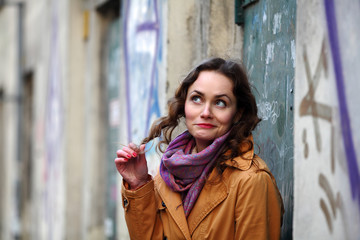 Fototapeta premium Beautiful brunette woman smiling and playing with her curly hair