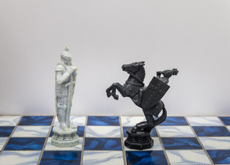 A pieces of chess character on the board with a light. A character represents strategy, planning, brave, betrayal, confrontation and competition. 