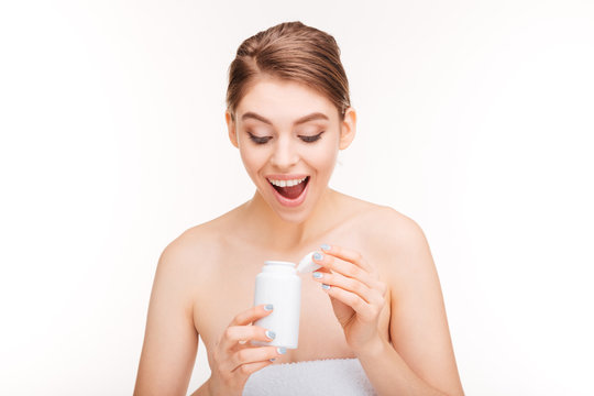 Happy woman holding bottle with pills
