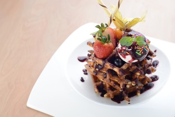 Chocolate Waffle topped with ice cream and strawberry