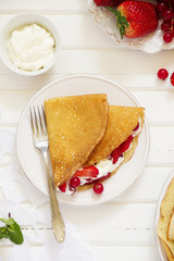 Pancakes filled with whipped cream and berries.