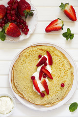 Pancakes filled with whipped cream and berries.