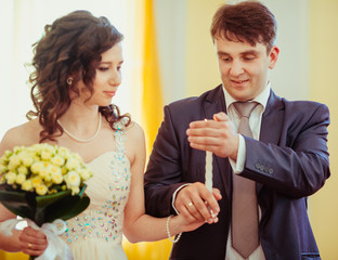 Happy newlywed couple holding candle on wedding ceremony