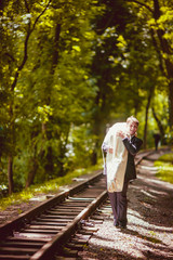 Fototapeta premium Happy newlywed romantic couple walking on rails in the park
