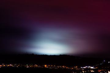 Light pollution from sports fields. A rainy night shows light from university pitches at night,...