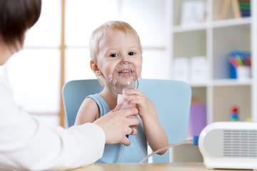 Child with asthma problems making inhalation with mask on her face