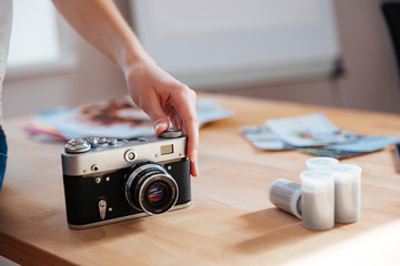 Vintage camera on the table used by young woman photographer