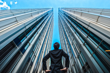 高層ビルを見上げるビジネスマン,ローアングル,オフィスビル