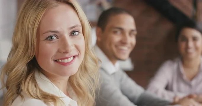 Portrait of a confident young business woman  at boardroom table In slow motion turning around and smiling