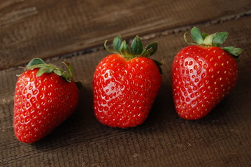 Red ripe strawberries on aged wooden table, close-up