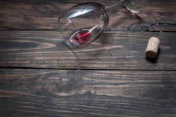 Wine glass, cork and corkscrew over wooden table with copy space