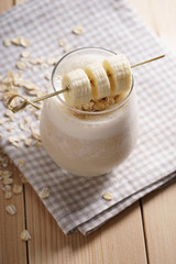 Banana smoothie on wooden background
