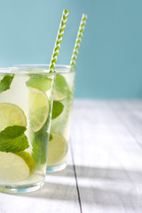 Summer drink. Fresh mojito with lime and mint. Blue background
