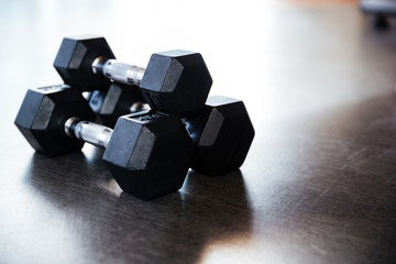 Three metal dumbbells on the floor in gym