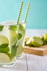 Fototapeta premium Summer drink. Fresh mojito with lime and mint. Blue background 