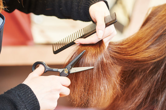 Hands of professional hair stylist with scissors and comb