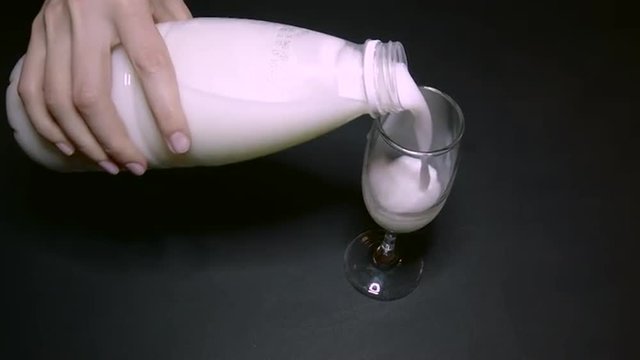 Woman Pouring Milk Into a Glass of Champagne
