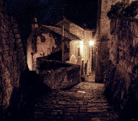 Fototapeta na wymiar Street of ancient medieval tuff city Sorano at night - travel european background
