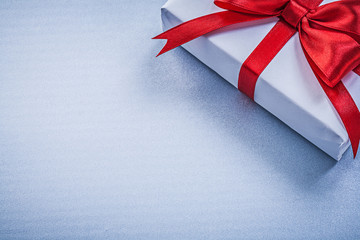 Present with red ribbon on blue background holidays concept