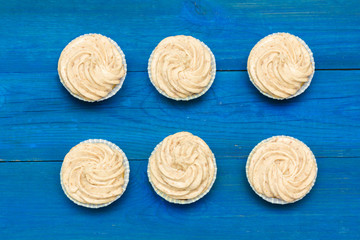 cupcakes with cream on the boards of blue