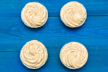 cupcakes with cream on the boards of blue