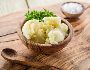 Mashed potatoes in the wooden bowl on the service tray.