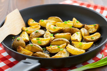 Tasty crispy potato wedges on a pan, vegetarian healthy food