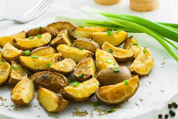 Fresh baked potato wedges on baking paper, homemade food, close-up