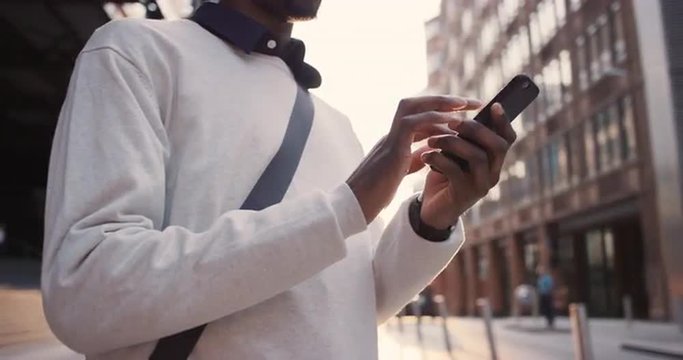 African American businessman through city using smart phone