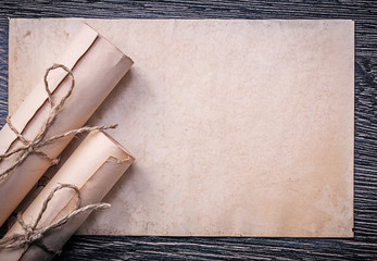 Vintage rolled up corded paper on wooden background