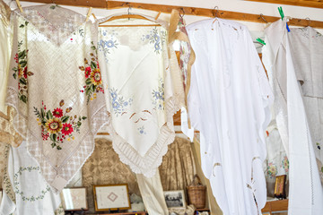 Fototapeta na wymiar Hand-made laces and needlework hang on shop wall. Pano Lefkara. Cyprus. 