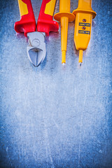 Yellow electrical tester cutting pliers on metallic background e