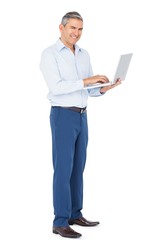 Smiling businessman typing on laptop