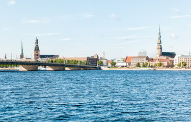 Fototapeta na wymiar Rigas Cathedral and Saint Peters Church view across the Daugava river and Stone bridge, Latvia
