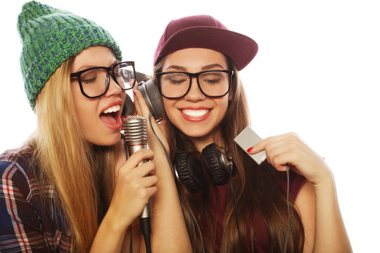  two beauty hipster girls with a microphone singing and having f