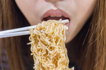 Noodle on chopsticks with people in background, shallow depth of © sirayot111