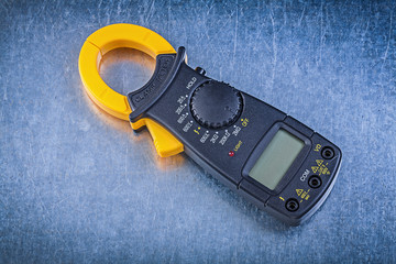 Digital clamp meter on metallic background